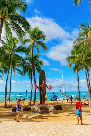Honolulu, Oahu, Hawaii - November 04, 2019: Duke Kahanamoku statue at Waikiki beach with unidentified people. Kahanamoku is a legendary swimmer who popularized the ancient Hawaiian sport of surfingのeditorial素材