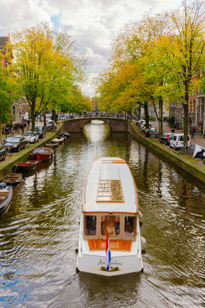 Amsterdam, Netherlands - October 28, 2019: cityscape with typical canal in Amsterdam, with unidentified people. Amsterdam is the capital and most populous city in the Netherlandsのeditorial素材