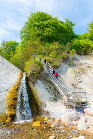 Glowe, Germany - May 10, 2018: view of the chalk cliffs of Ruegen with a waterfall and unidentified people. The area is part of the Jasmund National Park and part of the UNESCO world heritageのeditorial素材