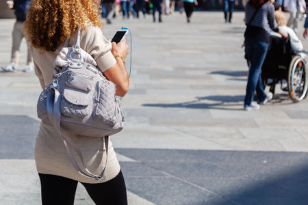 picture of a woman with handbag and phone on the move in the cityの写真素材