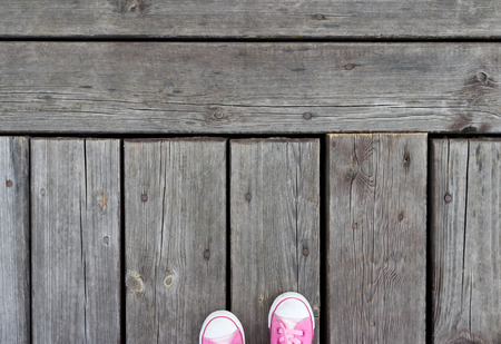 Pink shoes on a old wooden footbridgeの写真素材