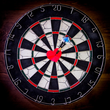 Darts arrow in the target center of the red heart.の写真素材