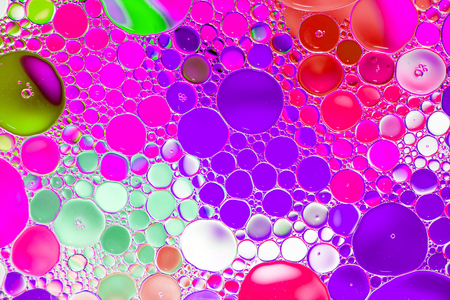 Oil drops in water on a coloured backgroundの写真素材