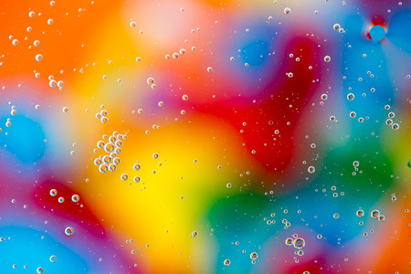 Oil drops in water on a coloured backgroundの写真素材
