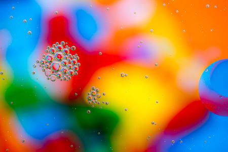 Oil drops in water on a coloured background