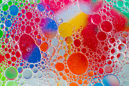 Oil drops in water on a coloured backgroundの写真素材