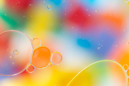 Oil drops in water on a coloured background