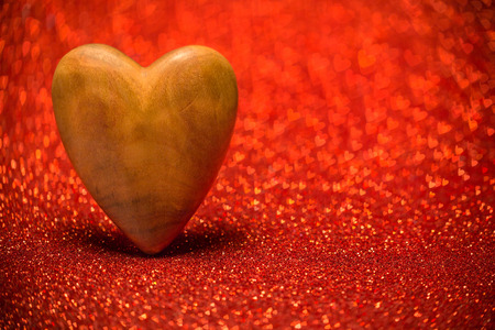 Wooden heart on a red blurred background.の写真素材