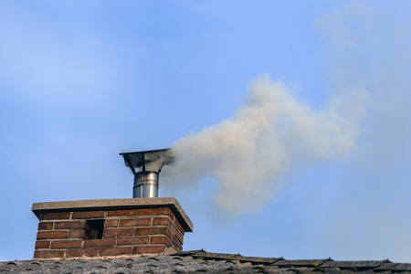 Smoke coming out of the house chimney.の写真素材