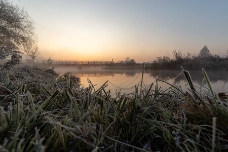 A beautiful sunrise over the misty riverの写真素材
