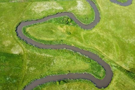 Aerial view landscape of winding river in green fieldの写真素材