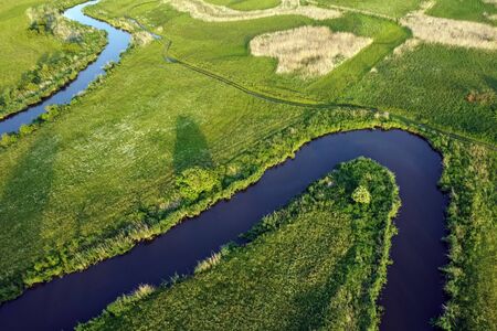 Aerial view landscape of winding river in green fieldの写真素材