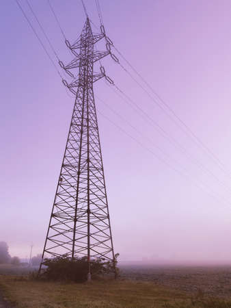 High voltage towers with sky background. purple toned images, foggy day, power line