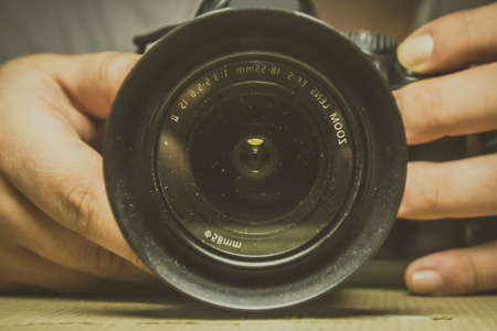 Two hands holding a camera. Vintage style type of shotの写真素材