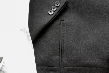 Close up of a few buttons on a business suit coat a nd a white shirtの写真素材