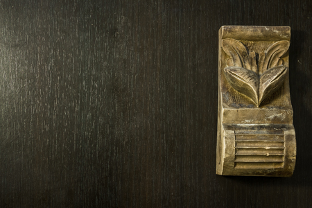 Beautiful pattern sculpted in wood on a dark wooden backgroundの写真素材