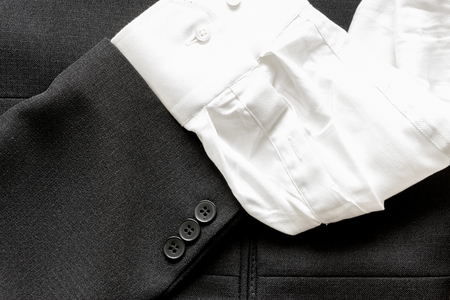 Close up of a few buttons on a business suit coat and white shirt sleeveの写真素材