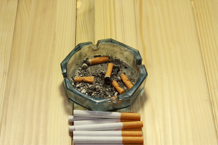 Shot of an ashtray with some finished cigarettes in it next to some untouched onesの写真素材