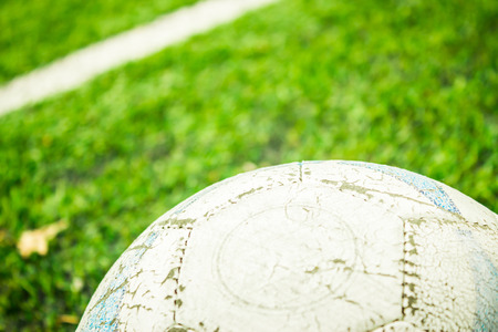 Closeup shot to a football field with delimitation line in it and alot of grass with a football in foregroundの写真素材