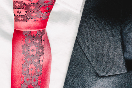 Closeup of a suit texture and a red tieの写真素材