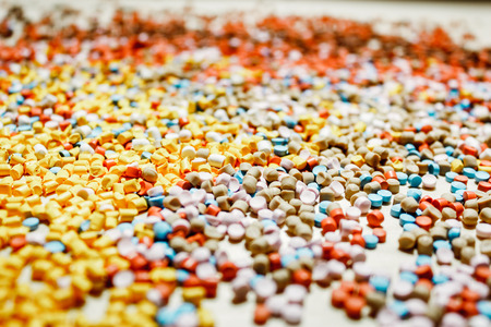 Shot of a few scattered plastic particles on a wooden tableの写真素材