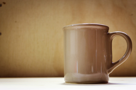 Shot of an empty coffee mug on a browny backgroundの写真素材