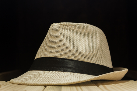 Fedora hat with dark backround on a wooden tableの写真素材