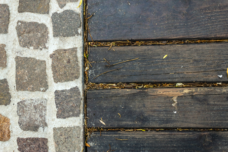 Shot to a few dark black wooden planks next to a rocky textureの写真素材