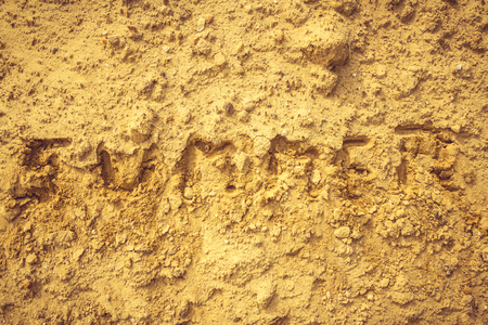 Closeup shot to summer word written in sand texture on a beach in summerの写真素材