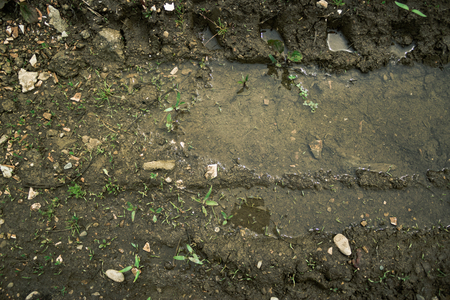 Closeup shot to a texture of wheel print in mud and waterの写真素材
