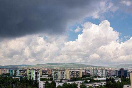 Storm clouds over a city surrounded by Natureの写真素材