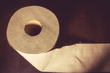 Close up shot to a toilette paper on a wooden background