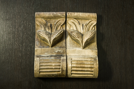 Beautiful pattern sculpted in wood on a dark wooden backgroundの写真素材