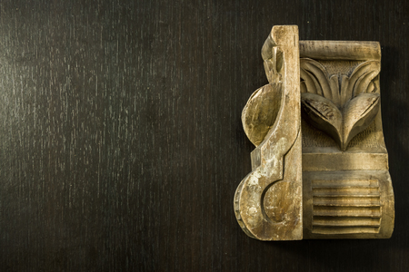 Beautiful pattern sculpted in wood on a dark wooden backgroundの写真素材
