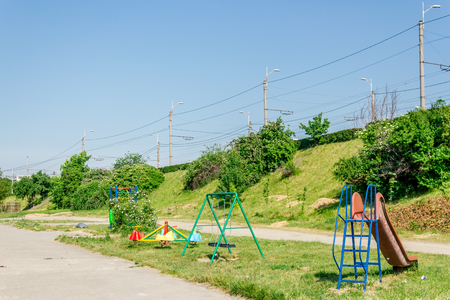 Playground for kids situated under a bridge in the summerの写真素材