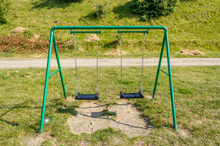 Shot to a green swing from a kids playground in the summer timeの写真素材