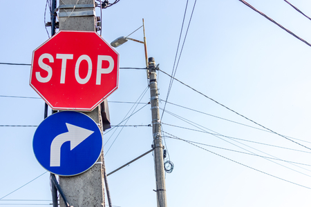 Stop traffic signs on a pillar warning you to stop and forcing you to turn rightの写真素材
