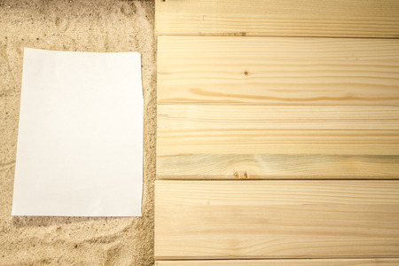 Summer beach backround made from some wooden planks, sand and a white plain piece of paperの写真素材