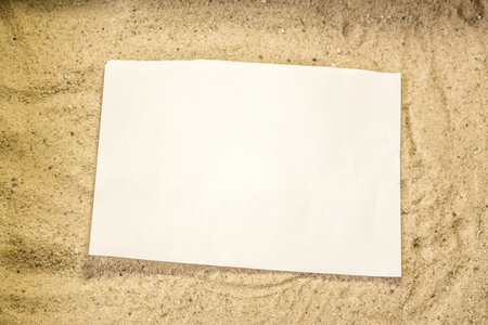 Summer beach backround made from a close up to the sand particles and a white plain piece of paper on top of itの写真素材