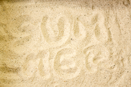 Summer beach backround made from a close up subtle word written in the sandの写真素材