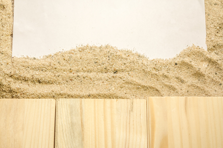 Summer beach backround made from some wooden planks, sand and a white plain piece of paperの写真素材