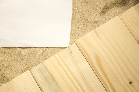 Summer beach backround made from some wooden planks, sand and a white plain piece of paperの写真素材