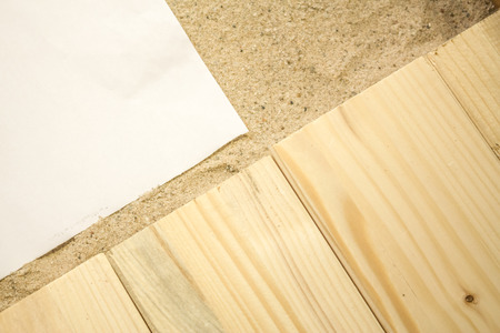 Summer beach backround made from some wooden planks, sand and a white plain piece of paperの写真素材