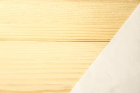 Close up shot to a wooden plank pattern and a white plain piece of paperの写真素材