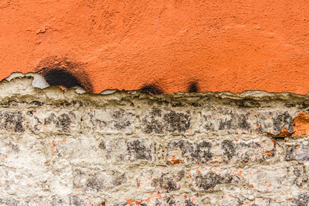 Close up shot to a corroded orange wall texture with bricksの写真素材