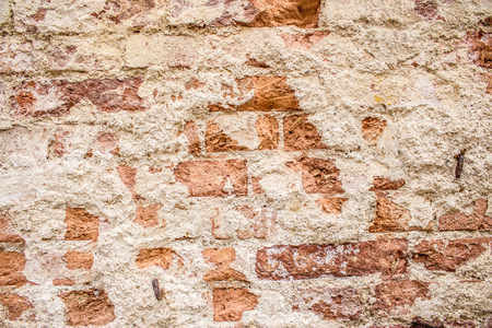 Close up shot to a corroded orange wall texture with bricksの写真素材