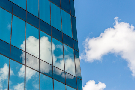 Clouds reflected in windows of a modern office buildingの写真素材