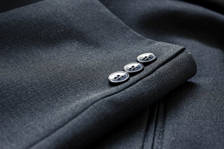 Close up of a few buttons on a business suit coatの写真素材