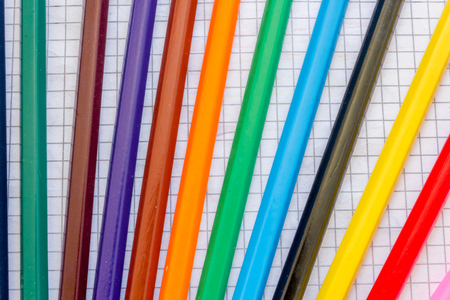Macro of a few colored pencils on tiled paperの写真素材