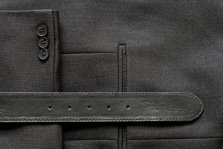 Close up of a few buttons on a business suit coat and a leather beltの写真素材